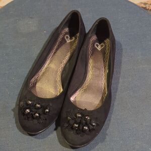 Black suede flats with silver and black flower embellishments by Madeline